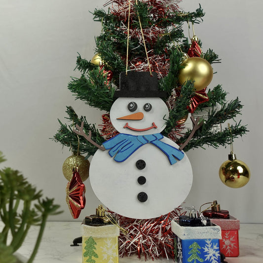 DIY Snowman with a blue collar and carrot nose on a decorated christmas tree